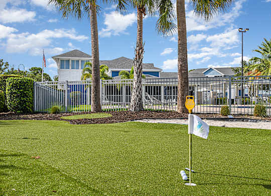 A golf course with a white flag on the green.