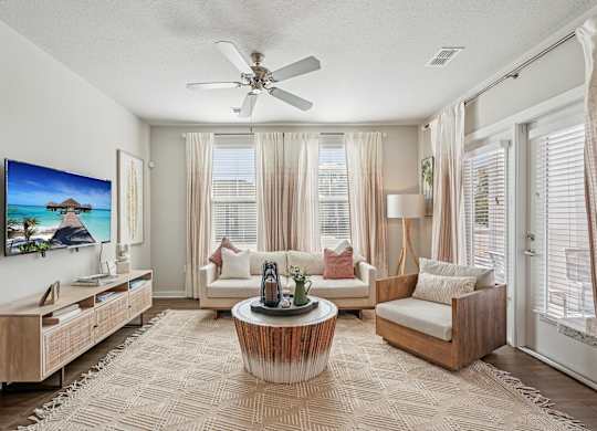A living room with a flat screen TV mounted on the wall.