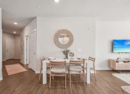 A dining room with a wooden table and chairs.