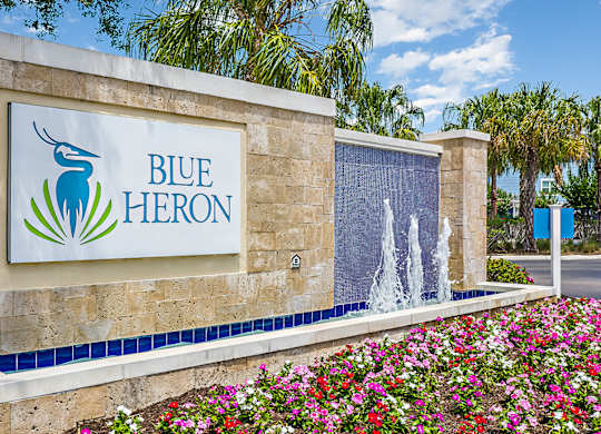 A sign for Blue Heron with a logo of a blue heron and a waterfall.