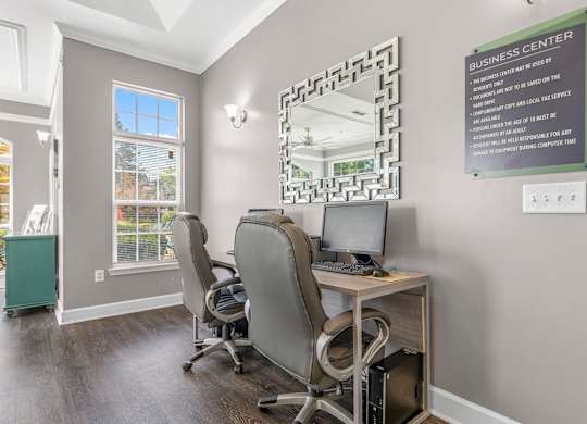 A business center with a sign on the wall and a mirror on the desk.