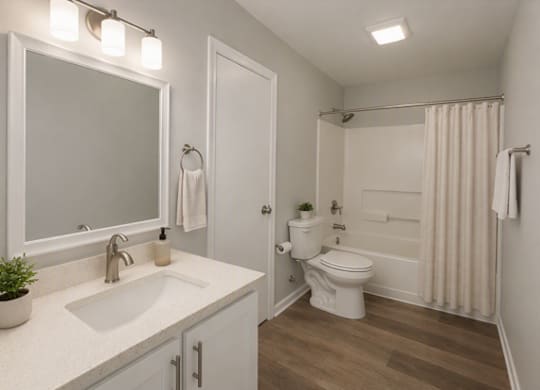 A white bathroom with a toilet, sink, and shower.