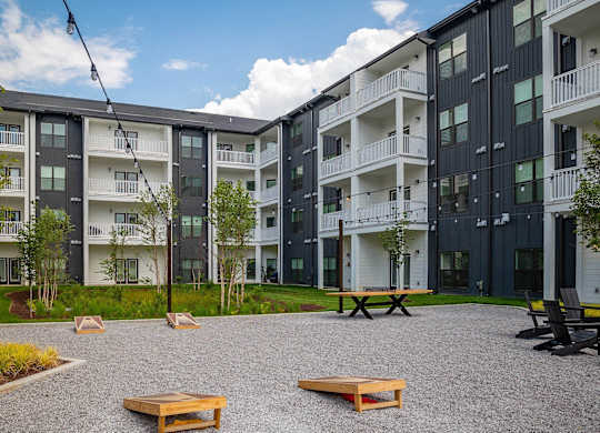 a courtyard between two apartment buildings with benches and grass