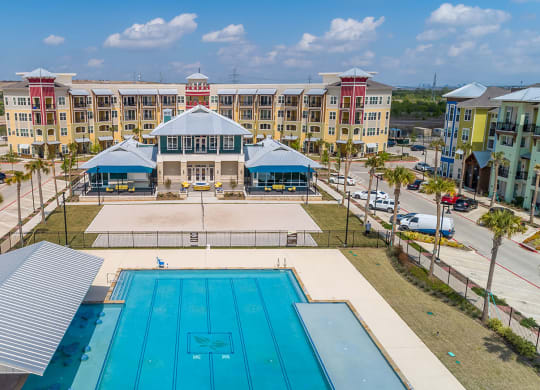 ewisville Apartments for Rent - Hebron 121 Station - Resort Style Pool with Lounge Seating, Clubhouse, and Volleyball Court