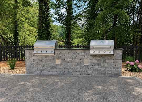 Two grills are built into a stone wall.