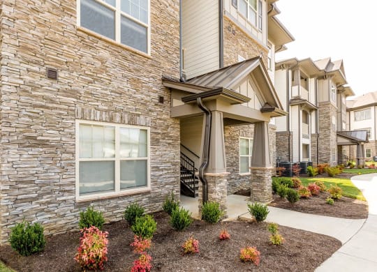 a view of the exterior of an apartment building with a sidewalk in front of it