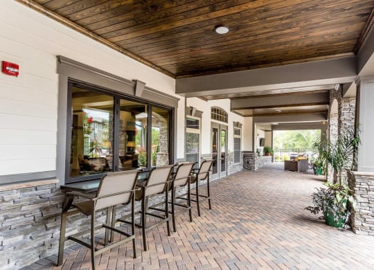 a covered patio with a table and chairs