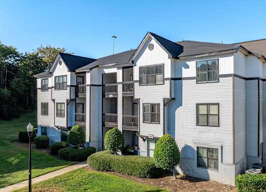 A large two-story apartment building with a balcony on the second floor.