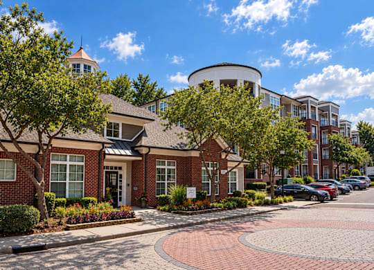 A red brick building with a circular driveway in front.
