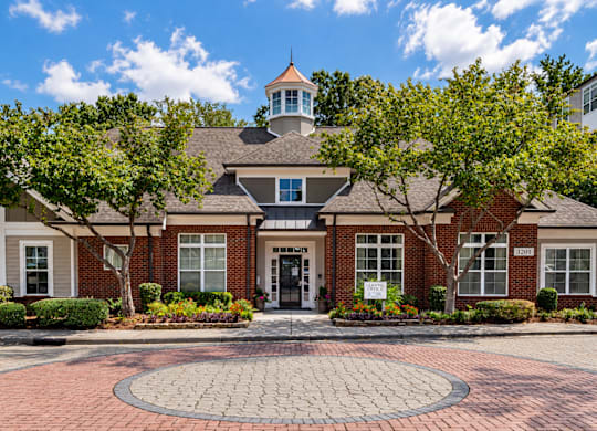 A building with a brick facade and a round brick walkway in front.