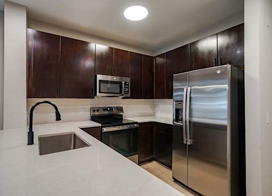 A kitchen with a stainless steel refrigerator and microwave.
