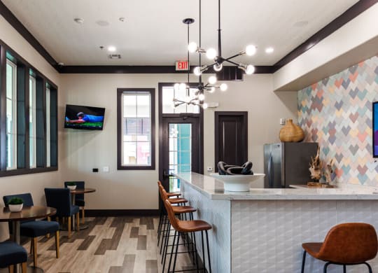 a lobby with a counter and chairs and a tv