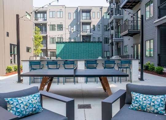 A patio with a table and chairs with a blue cushion.