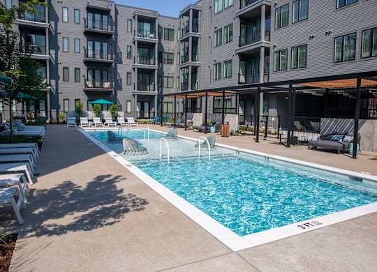 A swimming pool in front of apartment buildings.