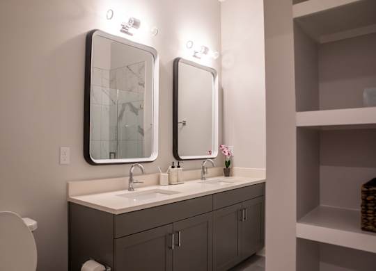 A bathroom with a white sink and a large mirror above it.