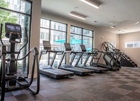 A gym with treadmills, elliptical machines, and a stair climber.