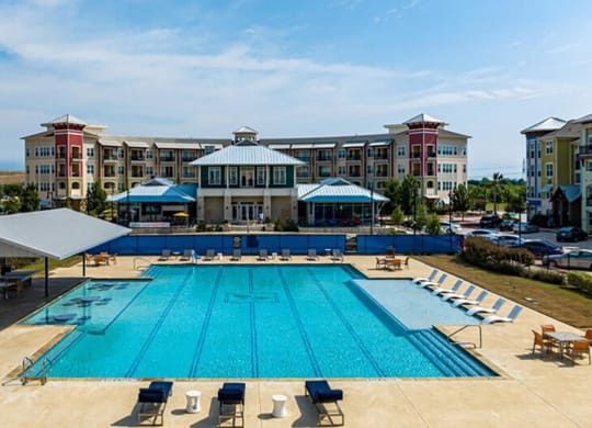 an aerial view of a swimming pool with apartments in the background