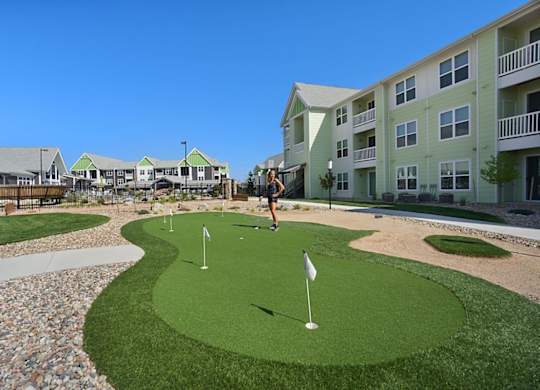 A person is playing mini golf on a sunny day.