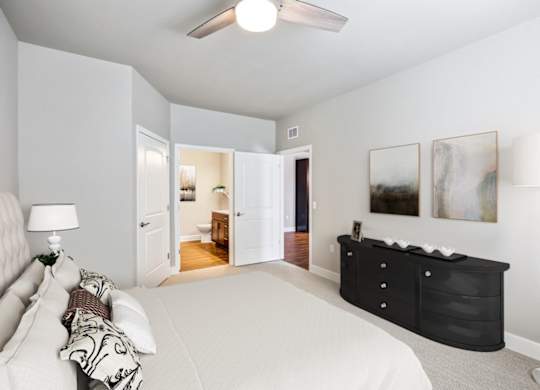 A bedroom with a large bed and a dresser.