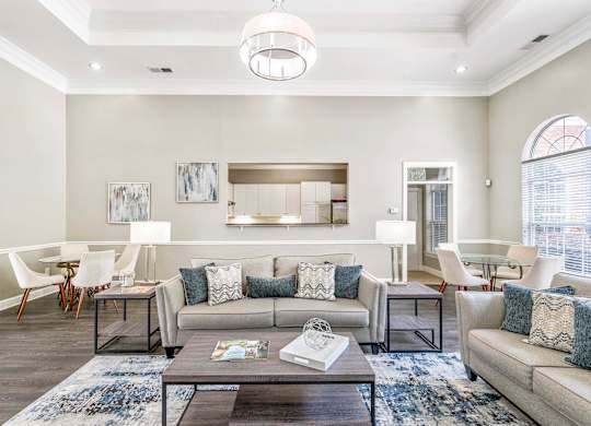 A modern living room with a grey sofa, a coffee table, and a large window.