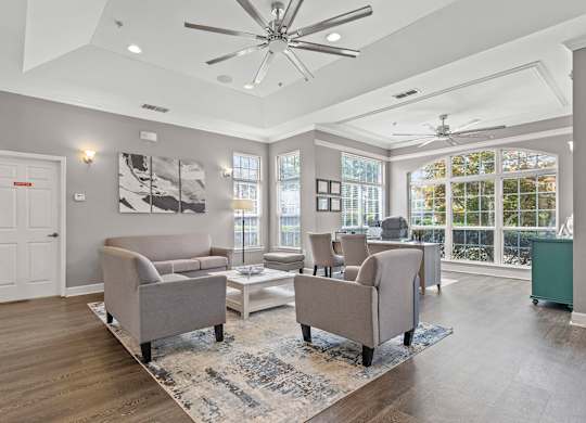 A spacious living room with a grey sofa set and a white coffee table.