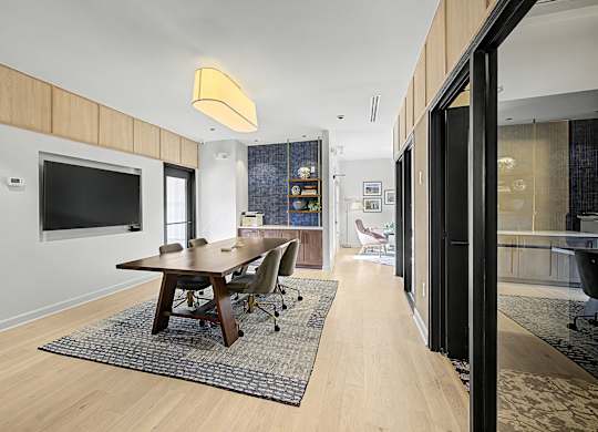 A modern dining room with a wooden table and chairs.