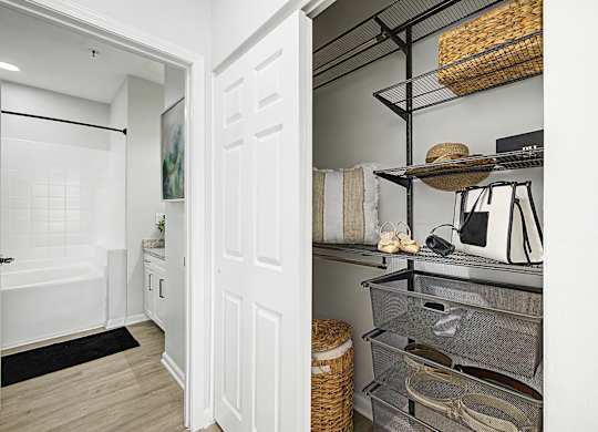 A white door opens to a kitchen with a white fridge and a white cabinet.