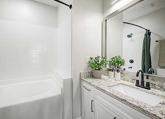 A white bathroom with a white tub and sink.