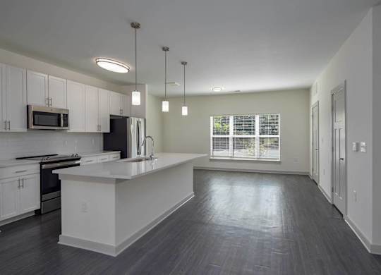 an empty kitchen with white cabinets and a white counter top