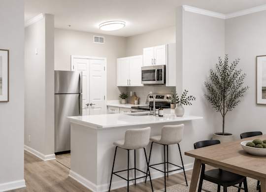 A modern kitchen with white cabinets and a wooden table.