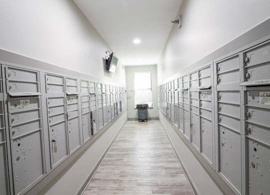 A long hallway with a series of lockers on the wall.