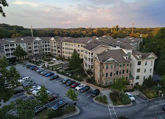 A parking lot is in front of apartment buildings.