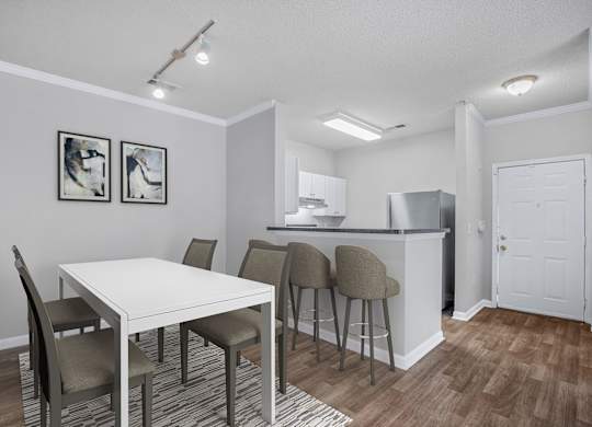 A kitchen with a dining table and chairs.