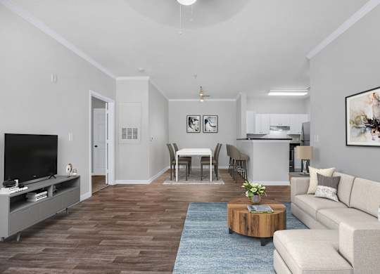 Fairburn, GA, Pet-Friendly Apartments - Orchard Springs Apartment Homes - A Contemporary Open-Concept Living Area Featuring A Cream Sectional, A Round Wood Coffee Table, And A Dedicated Dining Space.