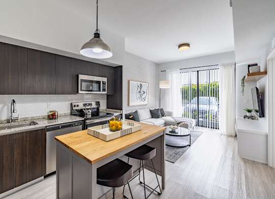 A modern kitchen with a wooden island and stainless steel appliances.