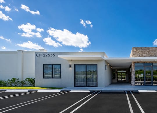 A modern building with a parking lot in front.