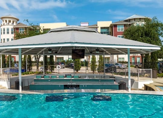 a swimming pool with a covered pavilion and a poolside jacuzzi