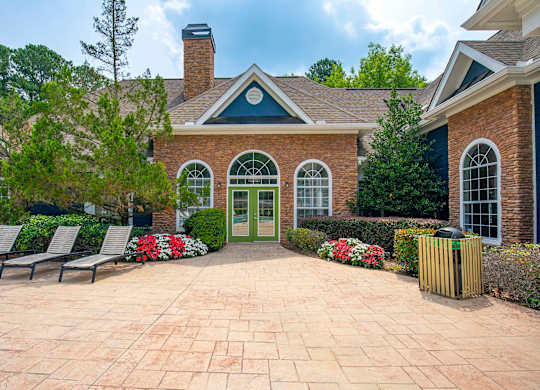 A brick house with a green door and a brick patio.