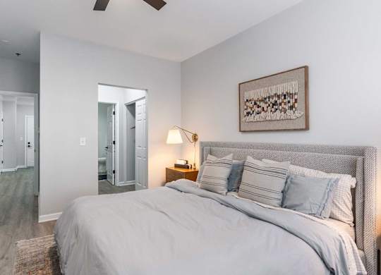 A bedroom with a large bed and a ceiling fan.