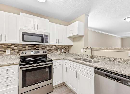 A kitchen with white cabinets and a black stove top oven.