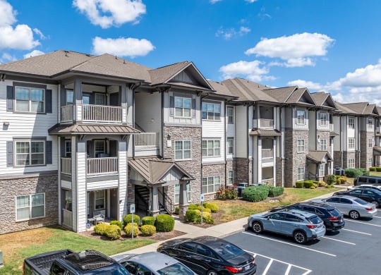an apartment building with cars parked in a parking lot
