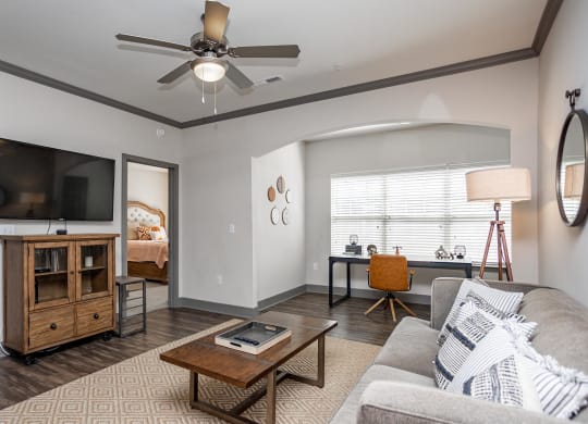 a living room with a ceiling fan and a tv