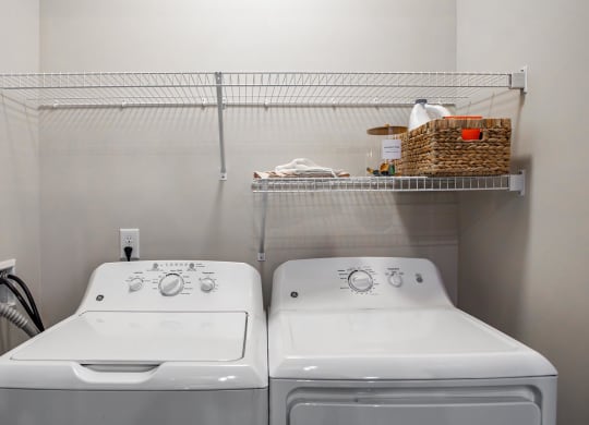 two washers and a dryer in a laundry room