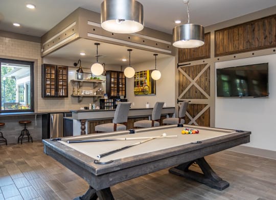 a games room with a pool table and a tv