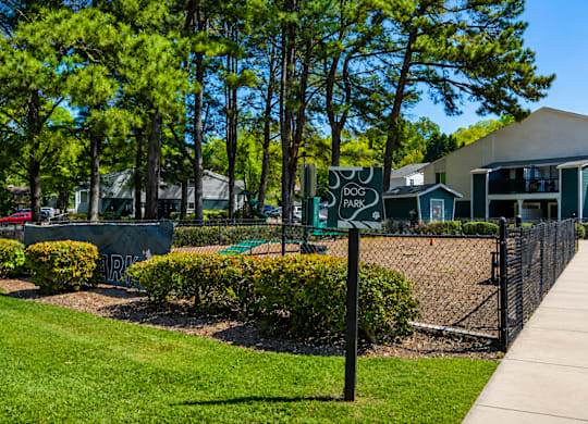 A sign for Dog Park is on a black fence.