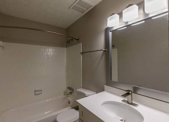 A white bathroom with a tub, toilet, and sink.