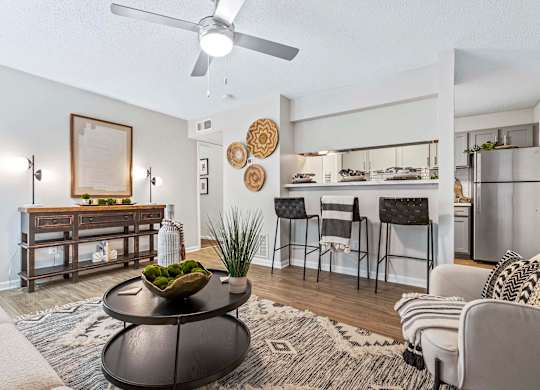 A living room with a black coffee table and a framed picture on the wall.