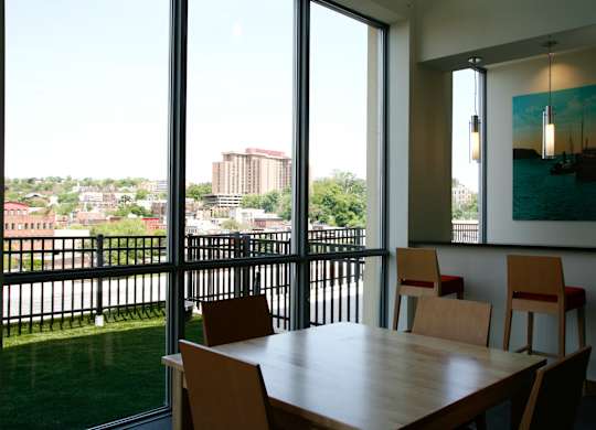 A table with chairs in front of a window with a view of a city.