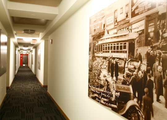 A long hallway with a picture of a street scene on the wall.