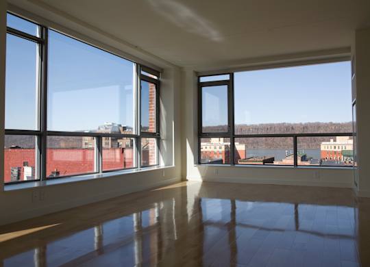 A large empty room with a view of the outside through large windows.